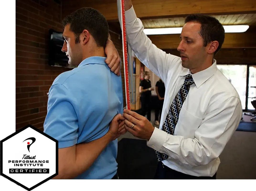 Dr. Dave Crosson measuring a patient's posture during a first-visit exam, with the Titleist Performance Institute Certified badge.