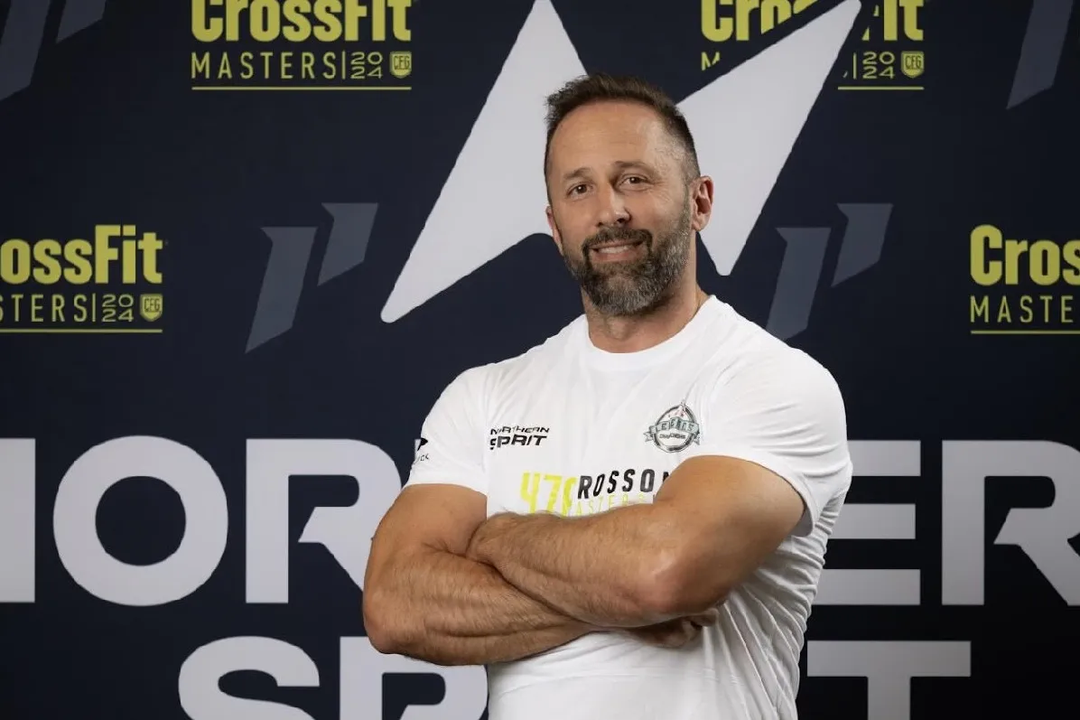 Dr. Dave Crosson standing with his arms crossed in front of a CrossFit Masters backdrop.